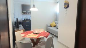 un tavolo e sedie in una piccola stanza con divano di Apto Santorini a Lauro de Freitas