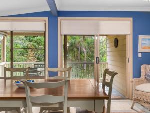 ein Esszimmer mit einem Tisch und Stühlen sowie einem Balkon in der Unterkunft Beachwood in Emerald Beach
