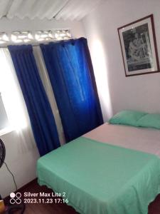 um quarto com 2 camas e uma cortina azul em Hotel Mariu em Melgar