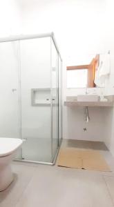 a bathroom with a glass shower and a sink at Brisa Mar Suítes in Arraial d'Ajuda
