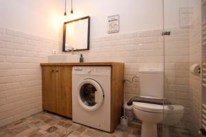 a bathroom with a washing machine and a toilet at Mill Central 2 in Sibiu