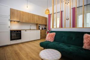 a living room with a green couch and a kitchen at Mill Central 2 in Sibiu