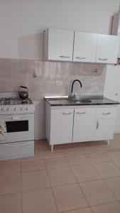 a white kitchen with a sink and a stove at Bella Vista in Gobernador Gregores