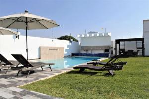 piscina con sedie e ombrellone e piscina di Serena Home a Oaxtepec
