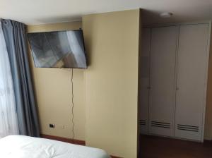 een slaapkamer met een bed en een tv aan de muur bij apartasuite sector marly-chapinero-palermo in Bogota