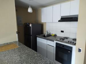 een keuken met een zwarte koelkast en een wastafel bij apartasuite sector marly-chapinero-palermo in Bogota