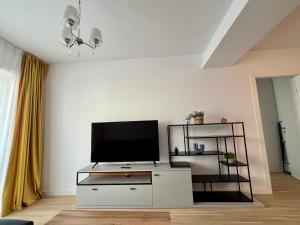 a living room with a tv on a white cabinet at C-entral Apartments Bucharest with Private Parking in Bucharest