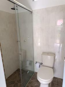 a bathroom with a toilet and a glass shower at Cabaña Sauce - Villeta in Villeta