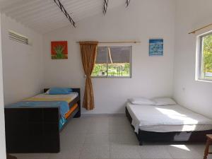 a bedroom with two beds and a window at Cabaña Sauce - Villeta in Villeta