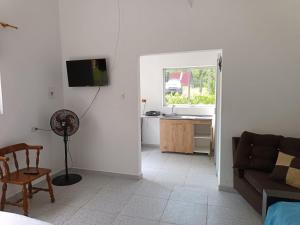 a living room with a couch and a kitchen with a window at Cabaña Sauce - Villeta in Villeta
