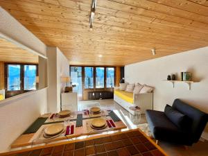 uma sala de estar com uma mesa e um sofá em THE ALPINE STUDIO proche du lac Frience, chiens admis, parking privé em Gryon