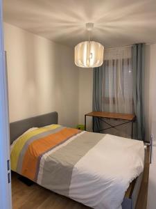 - une chambre avec un lit et un lustre dans l'établissement 2 bedroom Apartment + Parking, à Saint-Denis