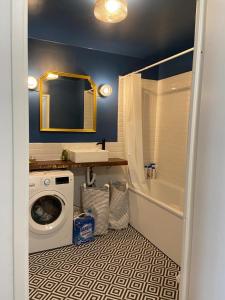 a bathroom with a washing machine and a sink at 2 bedroom Apartment + Parking in Saint-Denis