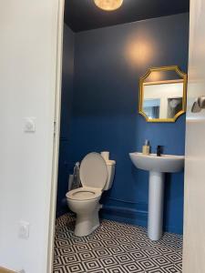 a blue bathroom with a toilet and a sink at 2 bedroom Apartment + Parking in Saint-Denis
