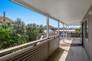 a balcony with a view of a house at The Sun Capsule - Ohope Beach Holiday Home in Ohope Beach