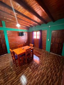 een eetkamer met een houten tafel en stoelen bij Departamentos La Familia in Mina Clavero
