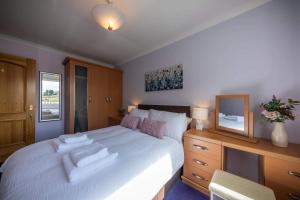 a bedroom with a bed with two towels on it at Loch Eyre Oasis in Kensaleyre