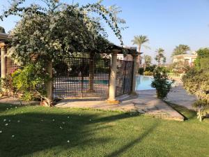 una valla junto a un patio con piscina en Ground floor villa with private garden, parking and shared swimming pool, en Al ‘Ajūzah