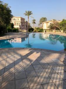 duży basen przed budynkiem w obiekcie Ground floor villa with private garden, parking and shared swimming pool w mieście El `Agûza