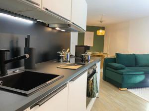 una cocina con fregadero y un sofá en una habitación en Bunker Studio Zentral Messe Business Streaming, en Essen