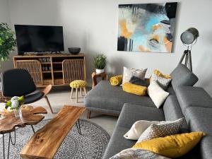 ein Wohnzimmer mit einem Sofa und einem TV in der Unterkunft Art Sunset Luxuary Villa in Ribeira Brava