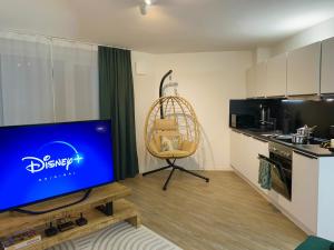 Una sala de estar con un televisor de pantalla plana y una silla. en Bunker Studio Zentral Messe Business Streaming, en Essen