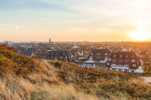 a view of a city at sunset from a hill at Dorint Strandresort & Spa Westerland/Sylt in Westerland
