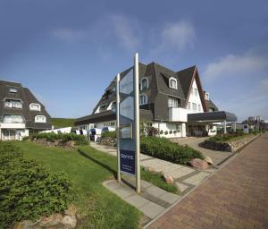 um sinal de rua em frente a uma casa em Dorint Strandresort & Spa Westerland/Sylt em Westerland