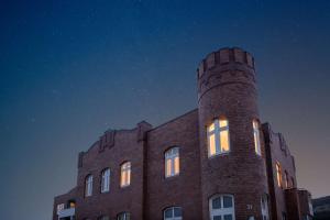 a brick building with its lights on at night at Dorint Strandresort & Spa Westerland/Sylt in Westerland
