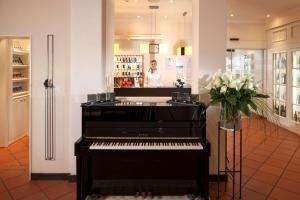 a man standing behind a piano in a store at Dorint Strandresort & Spa Westerland/Sylt in Westerland