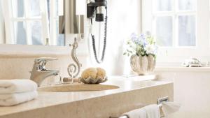 a bathroom counter with a sink and a mirror at Dorint Strandresort & Spa Westerland/Sylt in Westerland