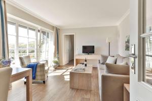 a living room with a couch and a tv at Dorint Strandresort & Spa Westerland/Sylt in Westerland
