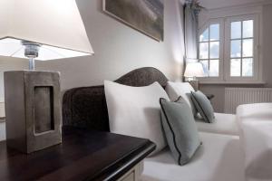 a living room with a white couch and a lamp at Dorint Strandresort & Spa Westerland/Sylt in Westerland