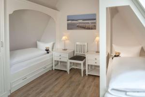 a bedroom with a bed and a desk with a chair at Dorint Strandresort & Spa Westerland/Sylt in Westerland