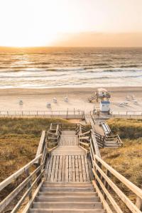 a stairway leading down to the beach with benches at Dorint Strandresort & Spa Westerland/Sylt in Westerland