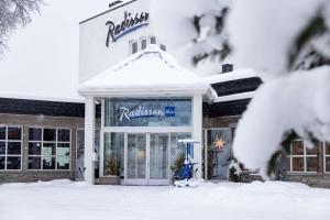 a restaurant covered in snow in front of a building at Radisson Blu Resort, Beitostølen in Beitostøl