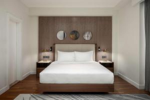 a bedroom with a large white bed and two tables at Radisson Hotel & Residences Erbil in Erbil