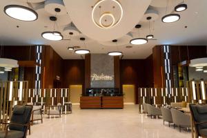 a dining room with tables and chairs and a large ceiling at Radisson Hotel & Residences Erbil in Erbil