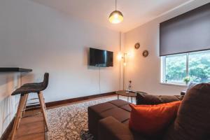 un soggiorno con divano e TV a schermo piatto di Noir - 2 Bedroom Flat - Sleeps 5 with Parking a Southampton