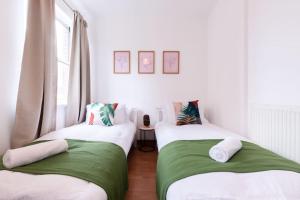 two beds in a room with white and green at Noir - 2 Bedroom Flat - Sleeps 5 with Parking in Southampton