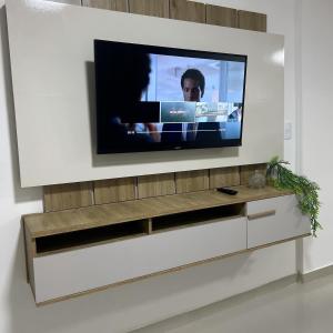 a television on a wall in a living room at Ap barra grande com piscina in Marau