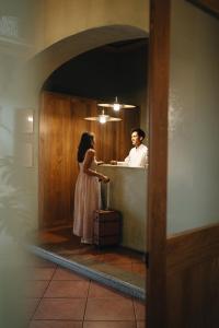 a man and a woman standing at a counter at Los Pilares Hotel in Oaxaca City