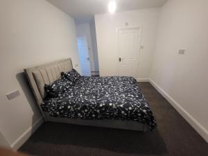 a bedroom with a bed with a black and white comforter at Hutton Lodge in Middlesbrough