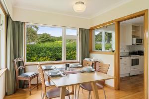 eine Küche und ein Esszimmer mit einem Tisch und Stühlen in der Unterkunft Kohekohe Garden Cottage - Waikanae Holiday Home in Waikanae