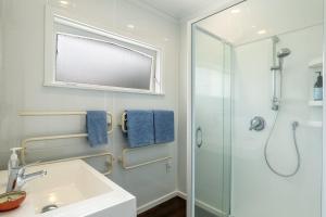 a bathroom with a sink and a shower at Kohekohe Garden Cottage - Waikanae Holiday Home in Waikanae +13 photos