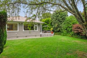 uma casa com um quintal com uma casa em Kohekohe Garden Cottage - Waikanae Holiday Home em Waikanae