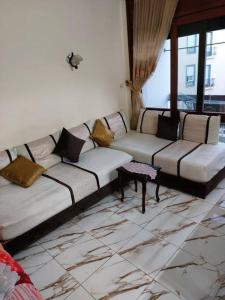 a living room with two couches and a window at Appartement au centre de Rabat à Hassan. in Rabat