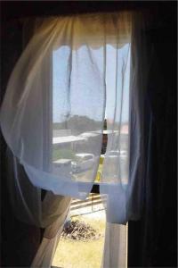 a view of a window with a white curtain at Casa en Valizas a 250m del mar in Barra de Valizas