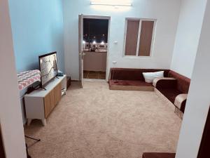 a living room with a couch and a television at Furnished Two bedroom apartment in Irbid in petra st in Irbid
