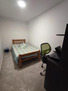 a bedroom with a bed and a desk with a mirror at Ninfa del Mar Hostal in Manizales